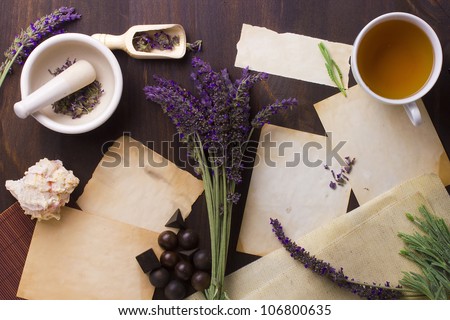 Directly above photograph of lavender flowers, papers, and decorative objects to portray the topic of alternative medicine. Add your text to the papers.