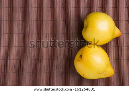 Yellow plums on a wooden mat. Fruit.