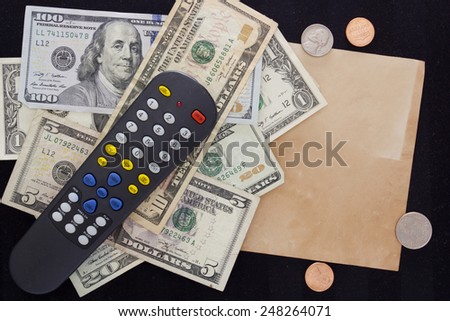 Utility bills - TV. TV remote switching channels with dollars and cents.