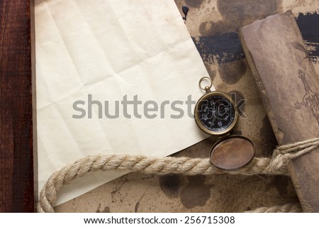 Roll of parchment with a compass and marine rope.