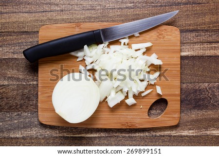Culinary processing onion - diced onion on a wooden chopping board.