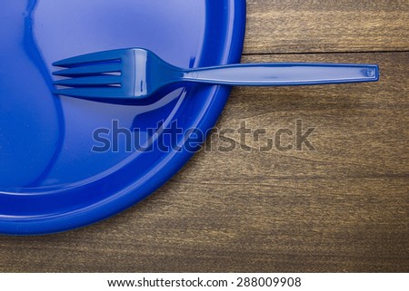 Plastic disposable fork and plates for going on a picnic.