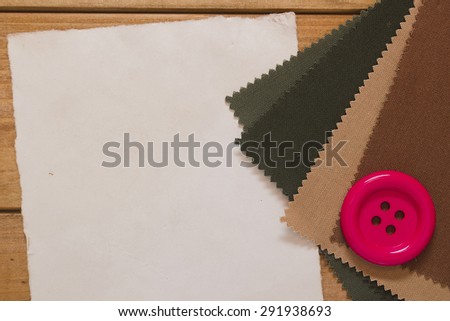A large red button on the cloth for needlework.