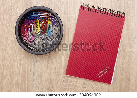 Office notebook and office paper clips on the desk.