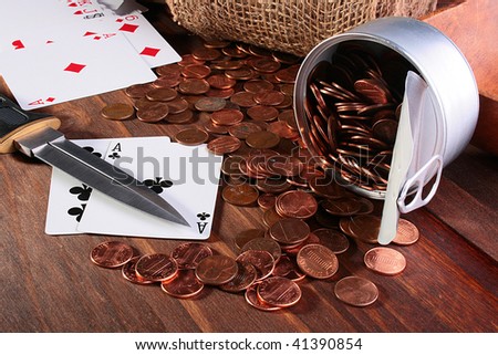 Money during a card play got enough sleep from banks on a wooden table. On a background cards and a knife, in the foreground two cards lie.