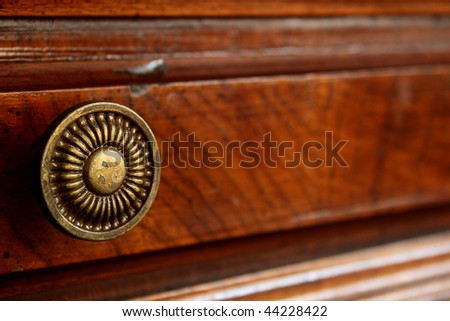 The ancient decorative handle of a box of a wooden desk.