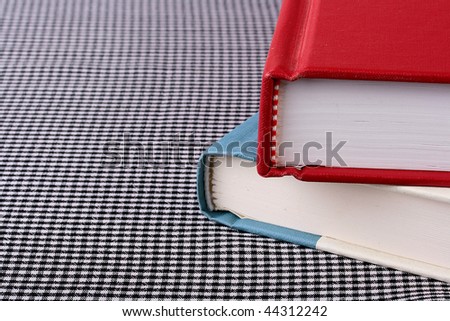 Two books on a table covered with a cloth in a white and black section.