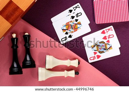 Opposition of two games: chess and cards. Kings and ladies against kings and queens.