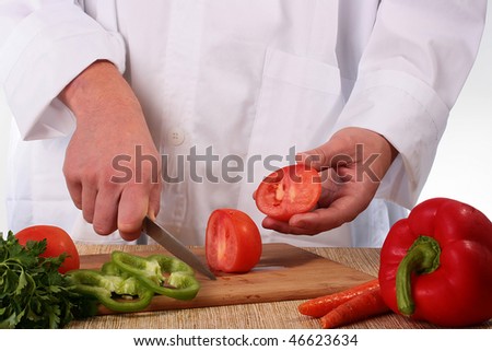The cook having cut a tomato shows the cut off part.