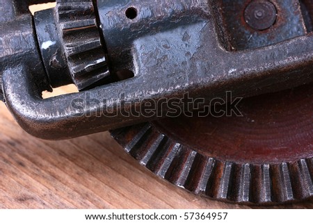 Old steel gear wheel on a wooden table.