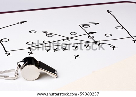 A silver whistle next to a drawing of a football play.