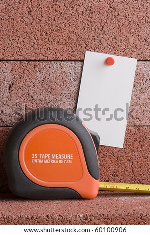 White piece of paper next to a tape measure. Add your text to the paper.