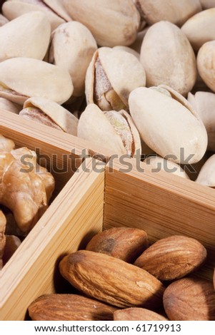Nuts Almond in a wooden box together with nuts of other grades.