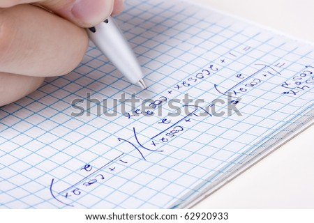 Student solving a math problem in a notebook.