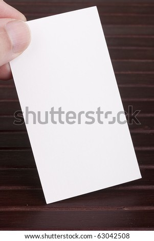 White sheet of construction paper in the form of a business card in a man\'s hand.