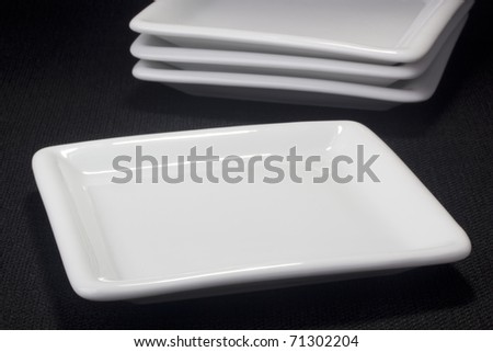 White square ceramic dish for dessert dishes on a black background.
