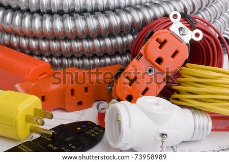 Electrical equipment laying on a series of electrical plans.
