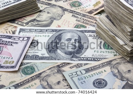 Variety of American money laid out under a stack of cash.