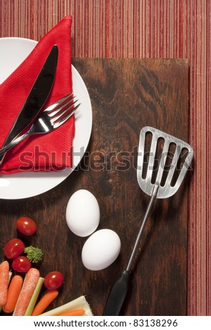 Eggs with vegetables and kitchen items on the kitchen table.