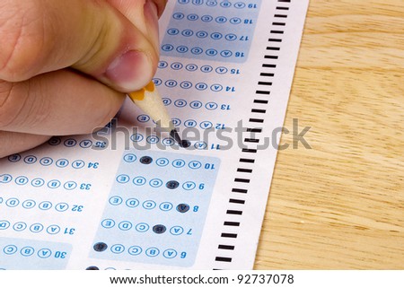 Student filling out answers to a test with a pencil.