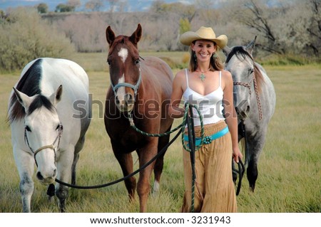 Cowgirl leading horses