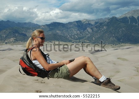 Woman sitting on sand dune