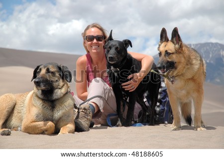 Woman sitting with three dogs