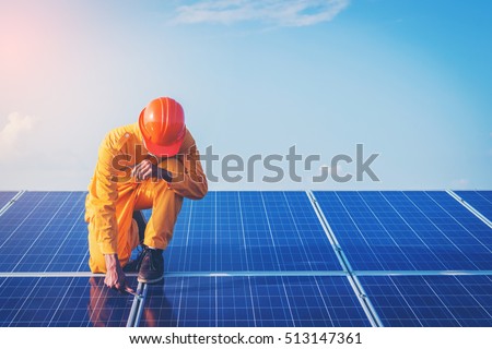 Filter and tone ;electrician working on checking and maintenance equipment at industry solar power; engineer standing on solar panel and feeling freedom at view point