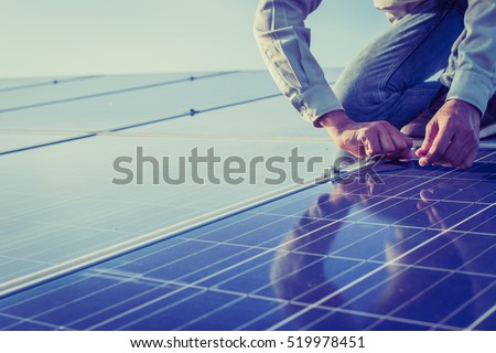 engineer working on checking and maintenance equipment at solar power plant: working on Wrench tightening solar mounting structure of solar panel