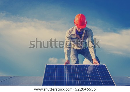 engineer or electrician working on replacement solar panel at solar power plant; working on repair solar panel to swap panel