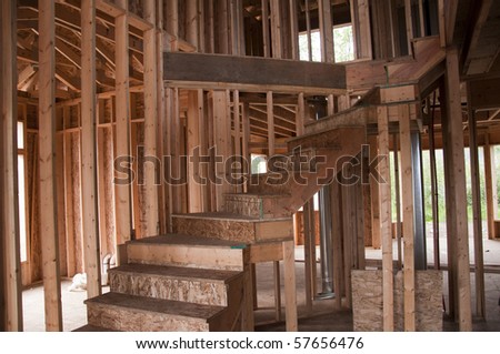 Rough framing of house with unfinished curved staircase