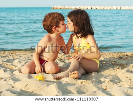 Children playing and kissing on the beach