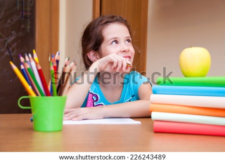 Girl thinking and writing on desk