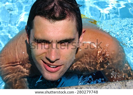 Young man posing in the swimming pool