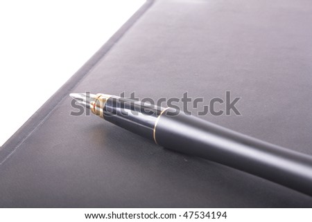 Black planner and pen on white background