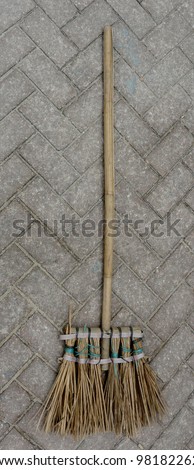 Old straw broomstick to sweep isolated on brick floor