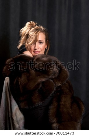 Portrait of a beautiful woman in winter clothes removed in studio