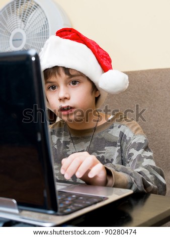 The boy writes the letter of Santa on email.