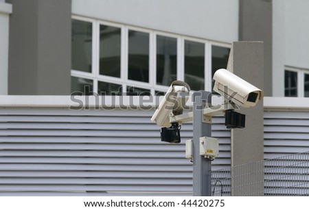 Two security cameras at the perimeter of a commercial office block