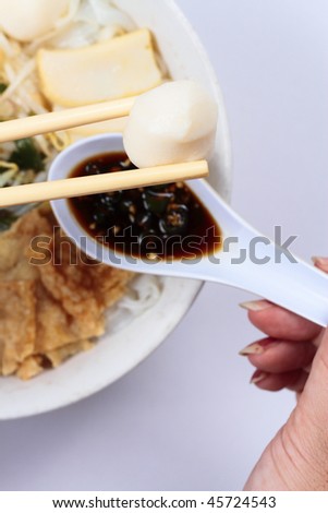 A bowl of Chinese flat noodles or \'koay teow\' with fish balls, fish cakes, bean sprouts and \'fuchuk\'