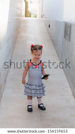 The beautiful caucasian  baby girl walking alone in street