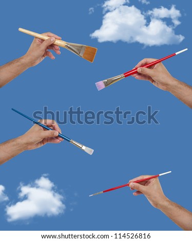 Several hands holding paint brushes