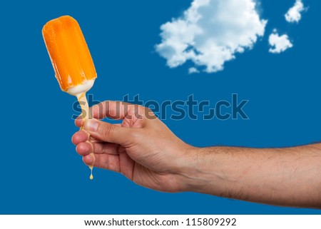 Hand holding melting ice cream bar