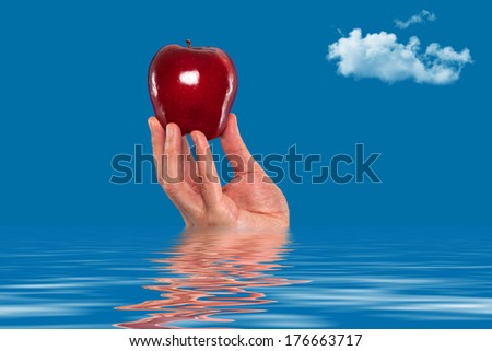 Hand holding an apple in the water