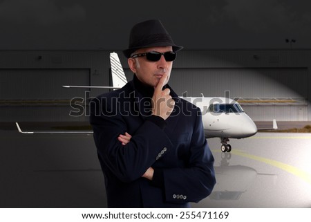 Business man standing next to private jet
