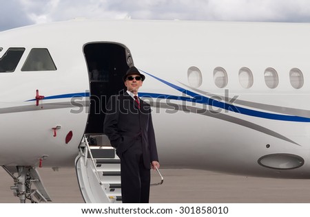 Handsome business man on the steps of a private jet