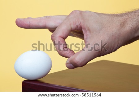 stock-photo-hand-about-to-flick-an-egg-58511564