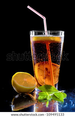 Iced tea and green leaf isolated on  black background