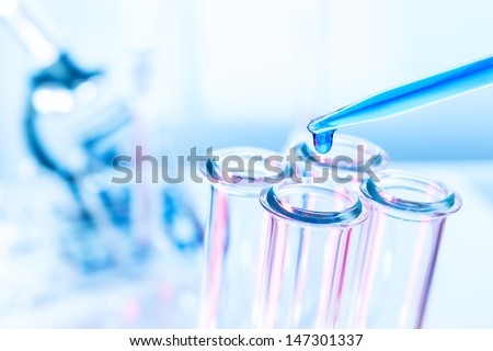 Pipette and test tube on blue background