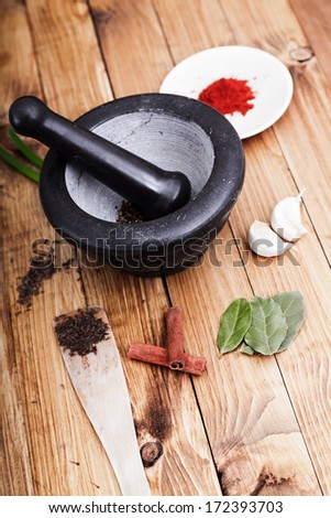 Tree spoons with spices and a bundle of herbs, mortar and pestle